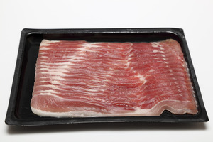 Sliced bacon packaged in a black plastic tray